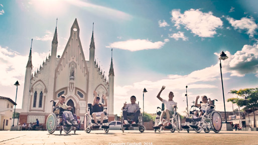 Niños en sillas de ruedas al frente de una iglesia Genfar